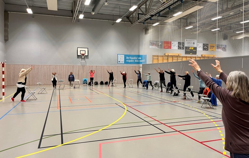 Bildet viser en halvsirkel med mennesker som står ved hver sin stor i Storhaughallen. De er på trening på Sterk og stødig. 