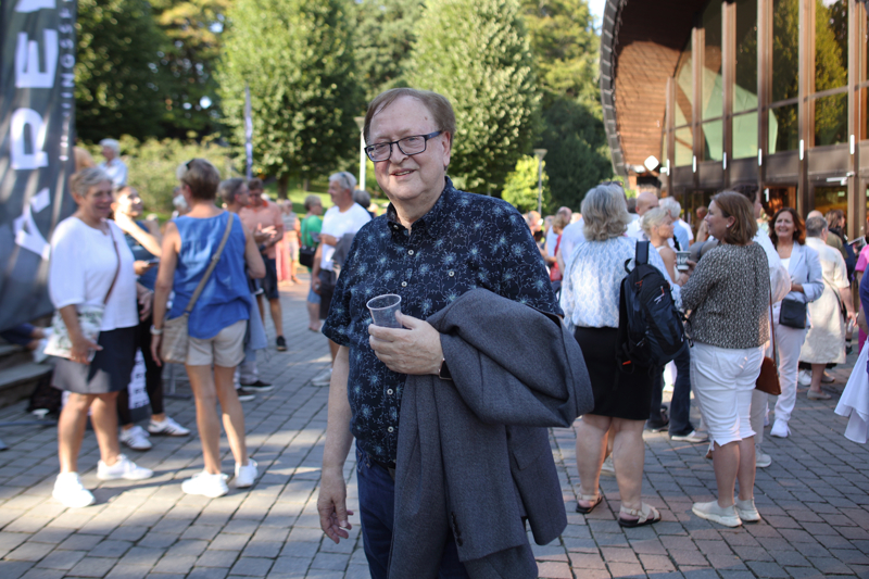 Kjell Carlsen som står utenfor Kuppelhallen med folk i bakgrunnen