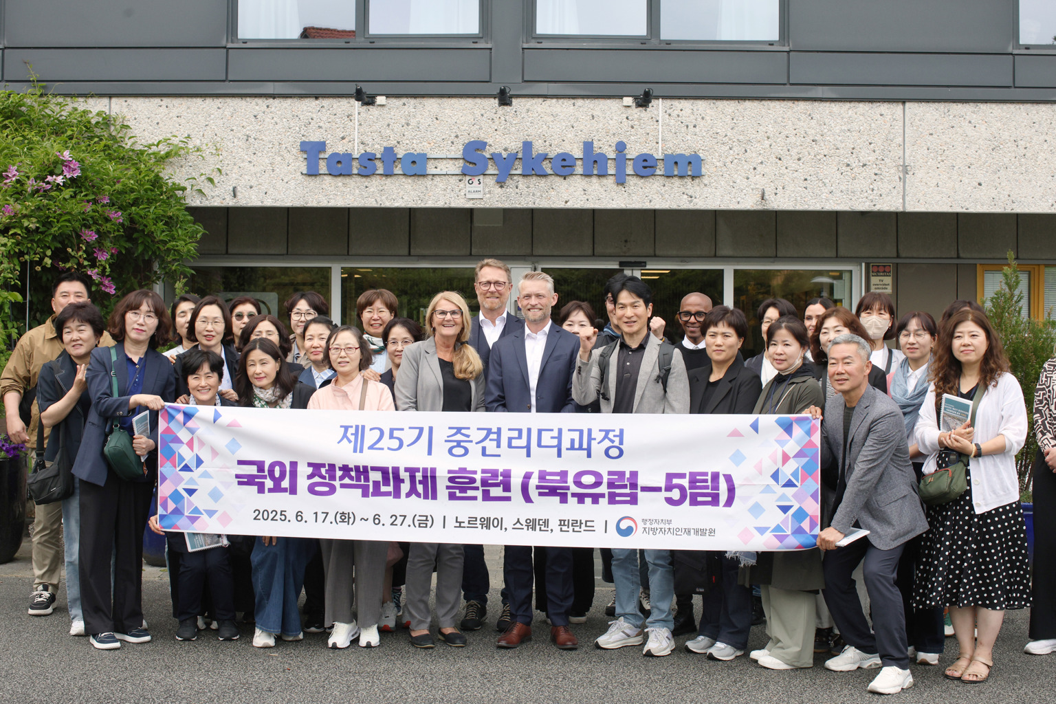 BESØK AV HELSELEDERE FRA SØR-KOREA: Delegasjonen sammen med i midten
virksomhetsleder Turid Eikeland Tjora, leder utvalg helse og velferd John Peter Hernes og kommunalsjef Helge Dragsund. En delegasjon på 30 sørkoreanere, en politiker og to fra Stavanger kommune står bak et stort banner med sørkoreansk skrift.