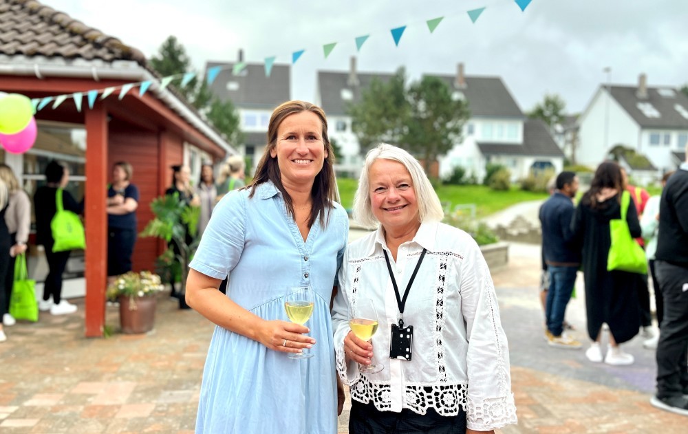 Vi Eli Mundheim og Kjersti Bjørnøy som står ved siden av hverandre med hvert sitt glass i hånden og smiler. Bak ser vi flere mennesker som deltar på markeringen.
