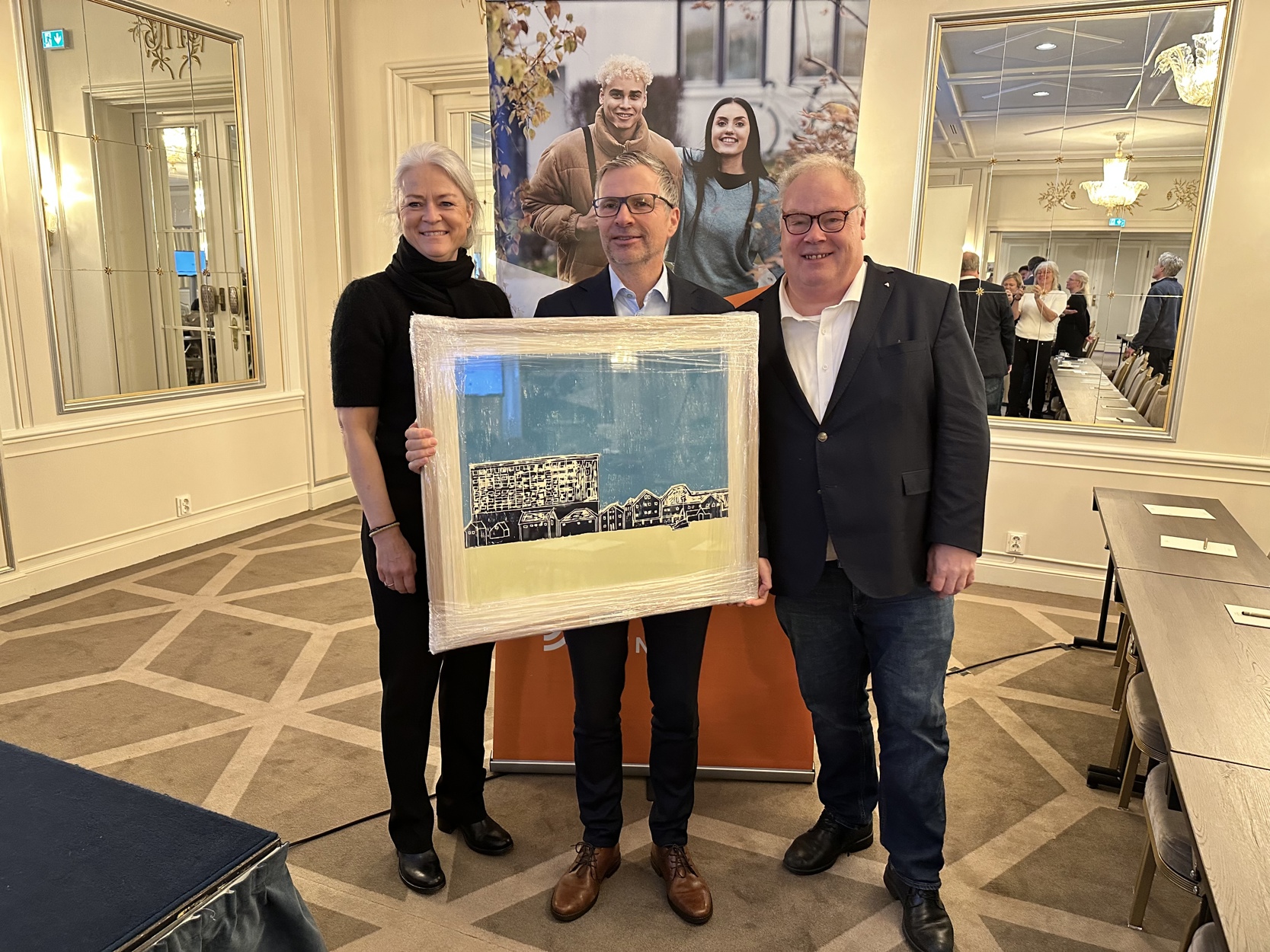 Under kåringen av årets mest boligvennlige kommune fikk Kaj Lea fra Stavanger kommune (i midten) overrukket et kunstverk av Anita Tjemsland av administrerende direktør Bård Folke Fredriksen i NBBL. Til venstre står Merete Eik fra Bate,