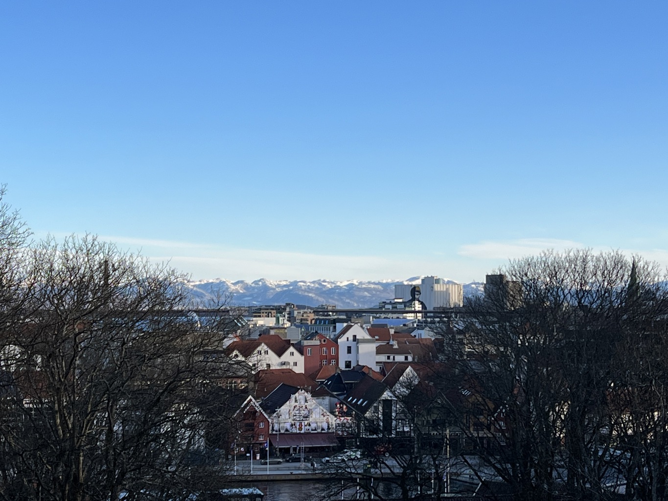KALDT OG STILLE: Denne værtypen får helsesjefen til å advare folk med helseproblemer mot å være for mye ute i områder med mye luftforurensning. Bilde av kaldt og klart vær, blå himmel, bybrua og fjell med snø på i bakgrunne.