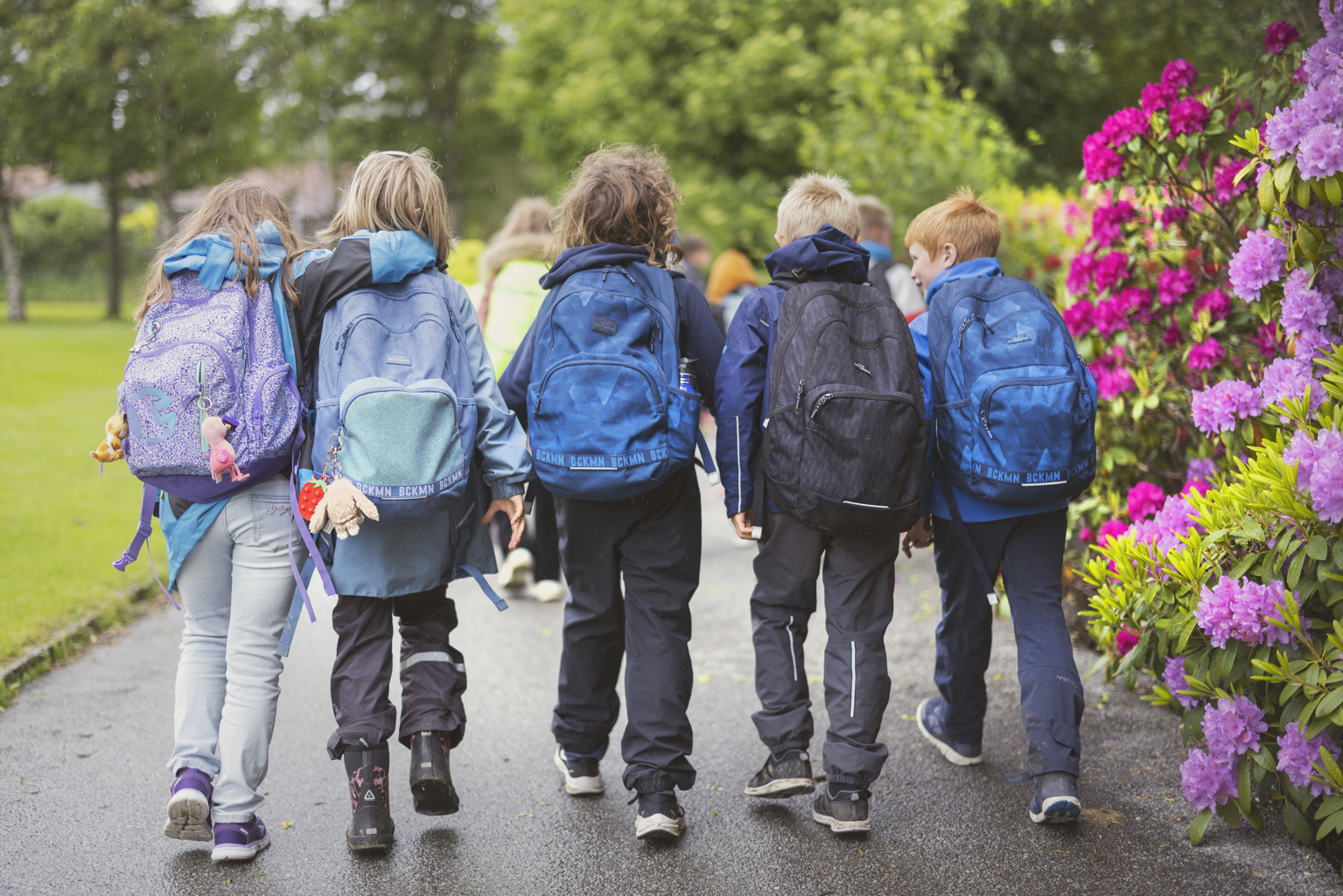 UT PÅ TUR: Bilder fra turer og arrangementer vil ikke lenger blir delt i sosiale medier på skoler og i barnehager. Bildet viser en gruppe skolebarn på tur. Bildet er tatt bakfra, barna har skolesekker og turtøy på.