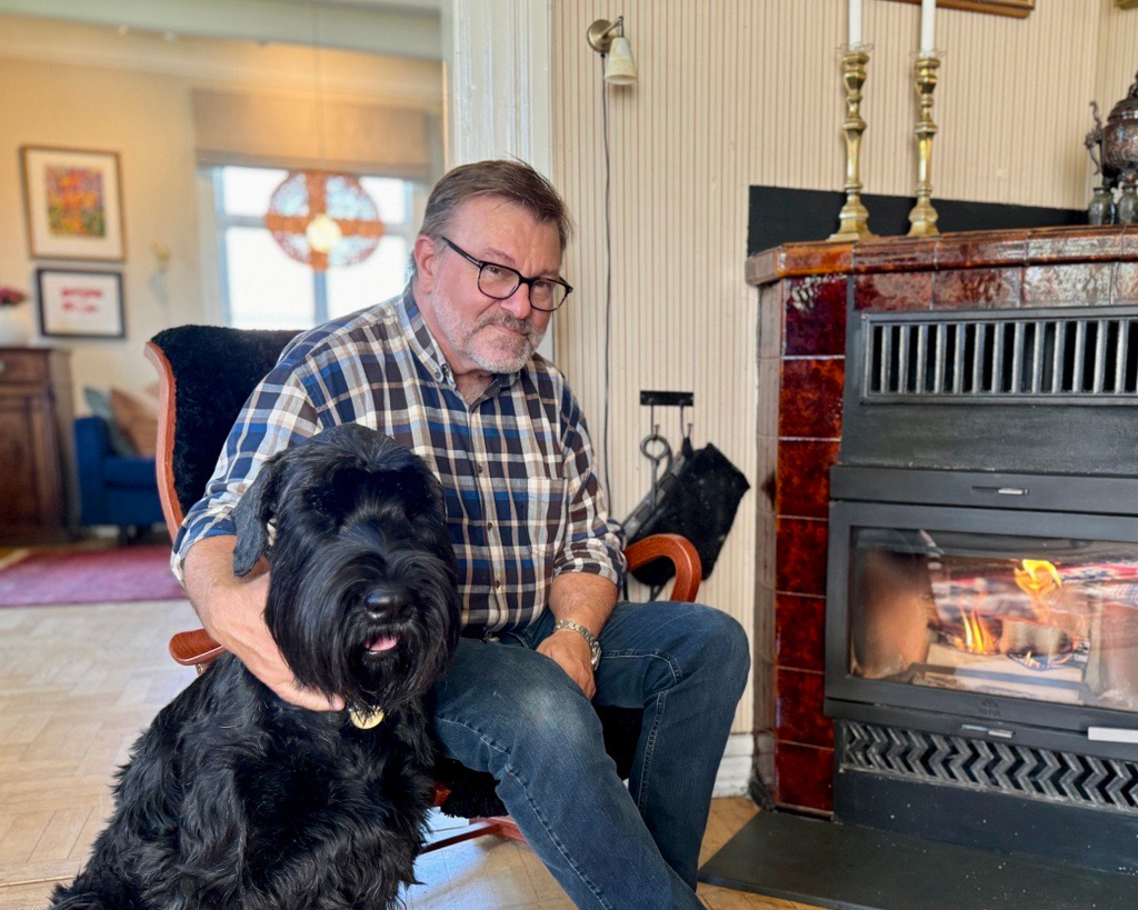 Hund og mann i stol ved peis