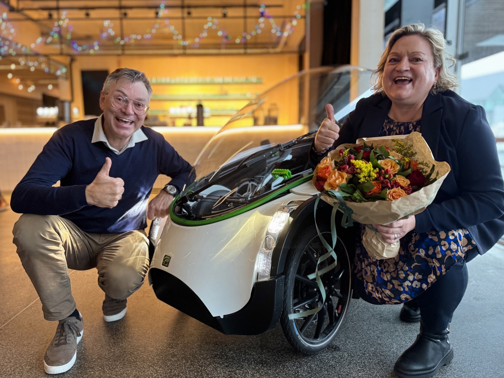 Per Hassel Sørensen og Anne-Lise Heggland sitter på huk ved podbike og jubler.