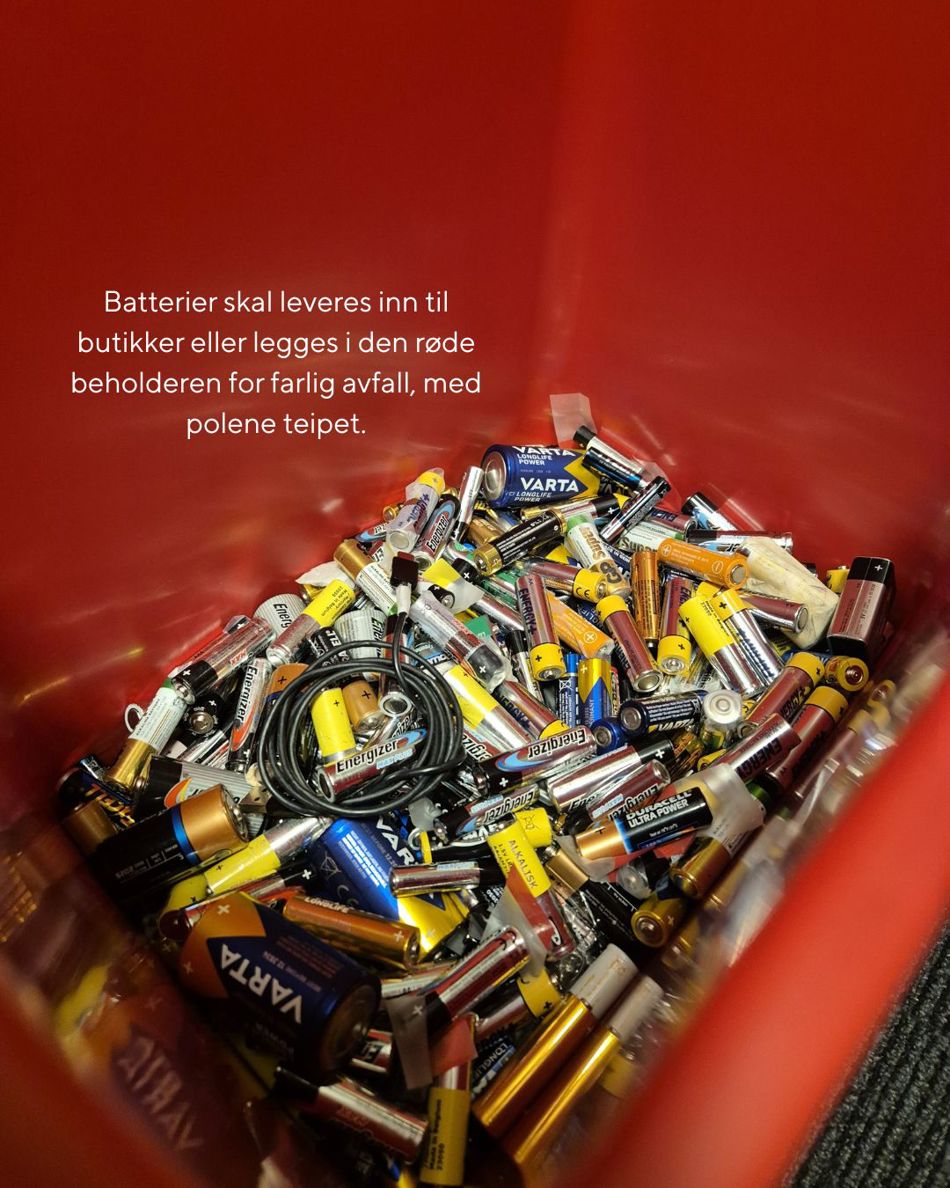 En rød beholder fylt med brukte batterier av ulike typer og størrelser, samt noen ledninger. Teksten på bildet informerer om at batterier skal leveres til butikk eller legges i rød beholder for farlig avfall, med polene teipet