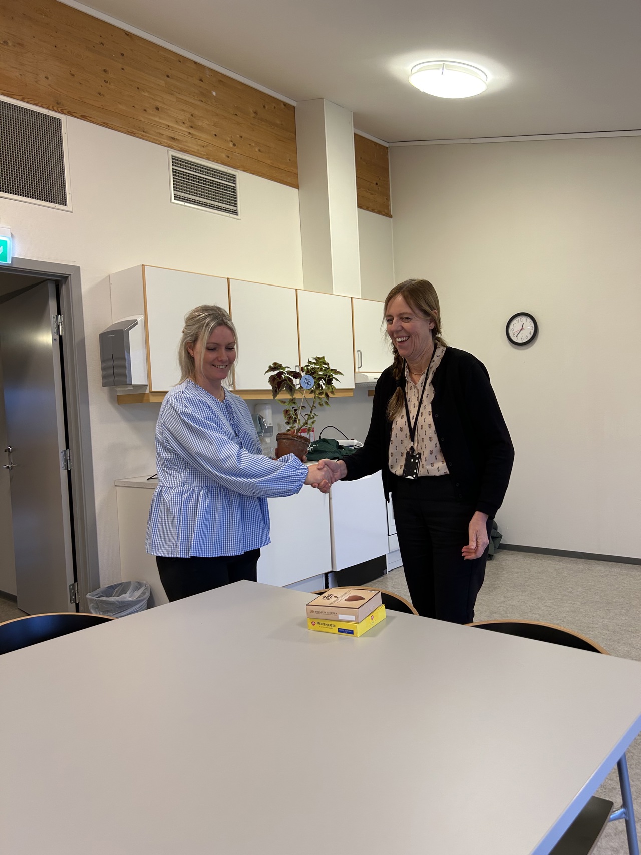 Charlotte Eriksen fra Bekkefaret aktivitetssenter og miljøvernsjef Jane Nilsen Aalhus med klimablomst og sjokolade i hånden