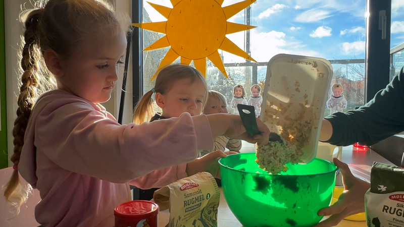 Signe Josefine lemper den kalde havregrøten oppi bollen.