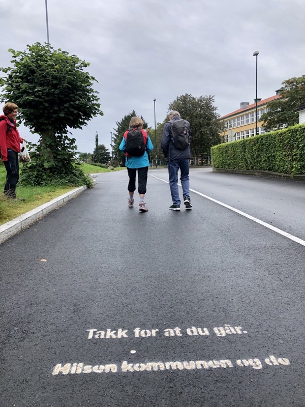 Teksten "Takk for at du går. Hilsen kommunen og de" er sprayet på fortauet.