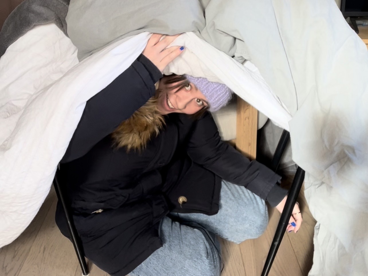 Har du ikke peis? Hvis strømmen går, kan du for eksempel holde varmen ved å kle på deg flere lag med vinterklær, og bygge et telt av varme pledd i stua! Har du ikke peis? Hvis strømmen går, kan du for eksempel holde varmen ved å kle på deg lag på lag med klær, og bygge et telt av varme pledd i stua! På bildet ser vi en godt kledd Emilie som titter ut av et slikt telt.