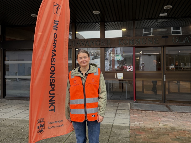 dame står ved siden av et flagg