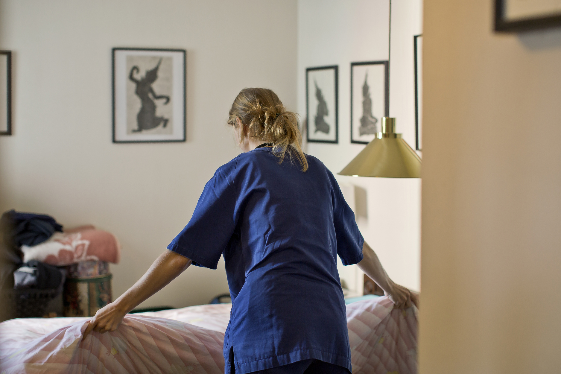 Bildet viser en hjemmehjelp som vasker og rer opp i en leilighet