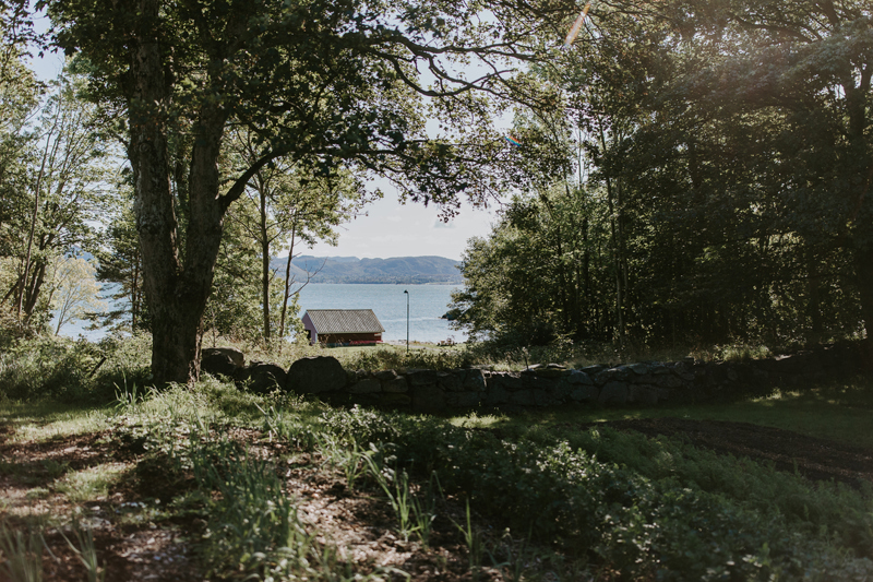 Grøntområde med et naust i bakgrunnen. 