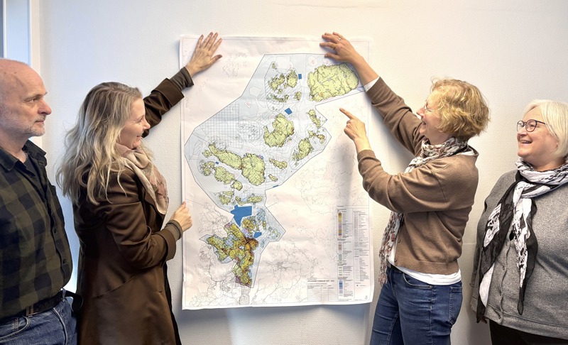 En mann og tre kvinner står og ser på et stort plankart over arealene i Stavanger kommune