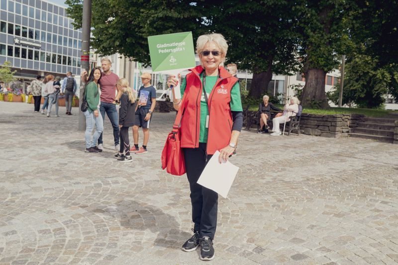 Bilde av dame som holder skilt til gladmatløypene. 