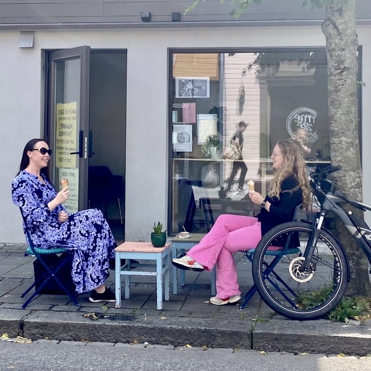 Marie Koch Singelstad , daglig leder i Grønn by, og Heather Bergsland, bærekraftsrådgiver i Veni, nyter sol og kaffe utenfor P23.