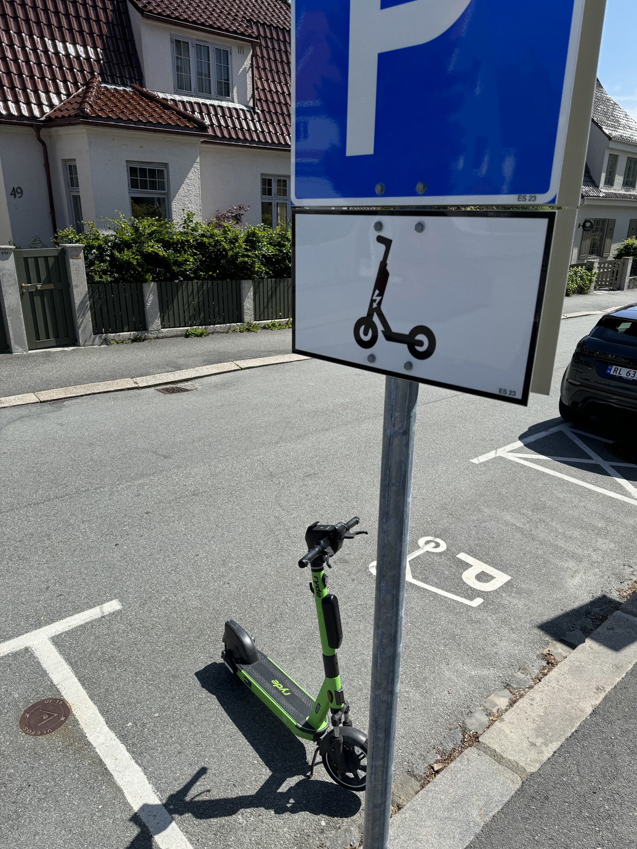 Elsparkesykkel står parkert på parkeringsplass for elsparkesykkel. Skilt i forgrunnen.