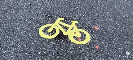 Gult sykkelsymbol malt på asfalt