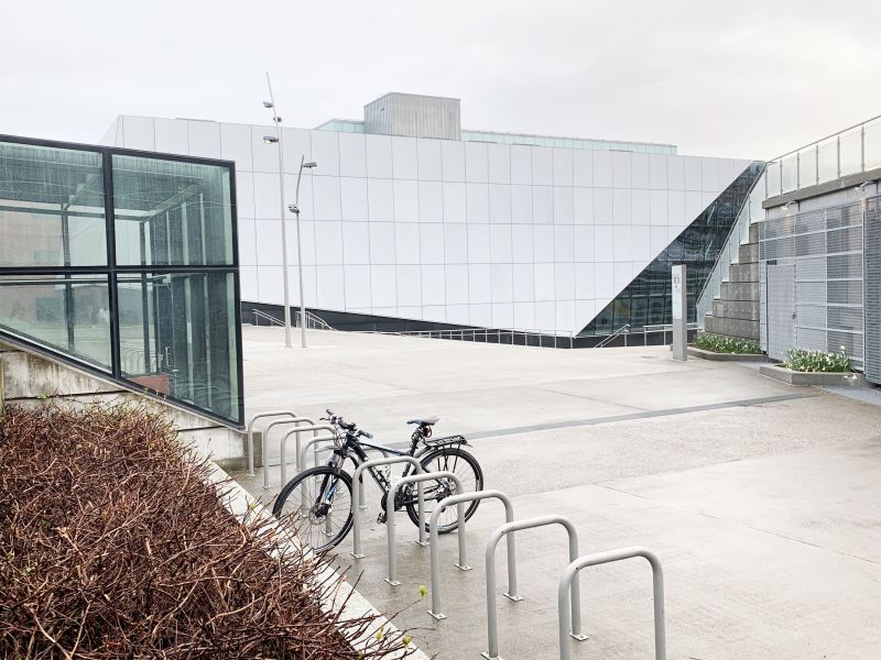 I bakgrunnen er Stavanger konserthus mens i forgrunnen parkerer en sykkel i en av mange sykkelstativer.