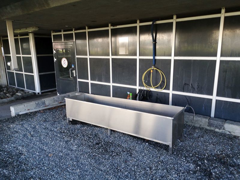 Utenfor sykkelparkeringshuset står en slags badekar der sykler kan vaskes i med en vannslange. 